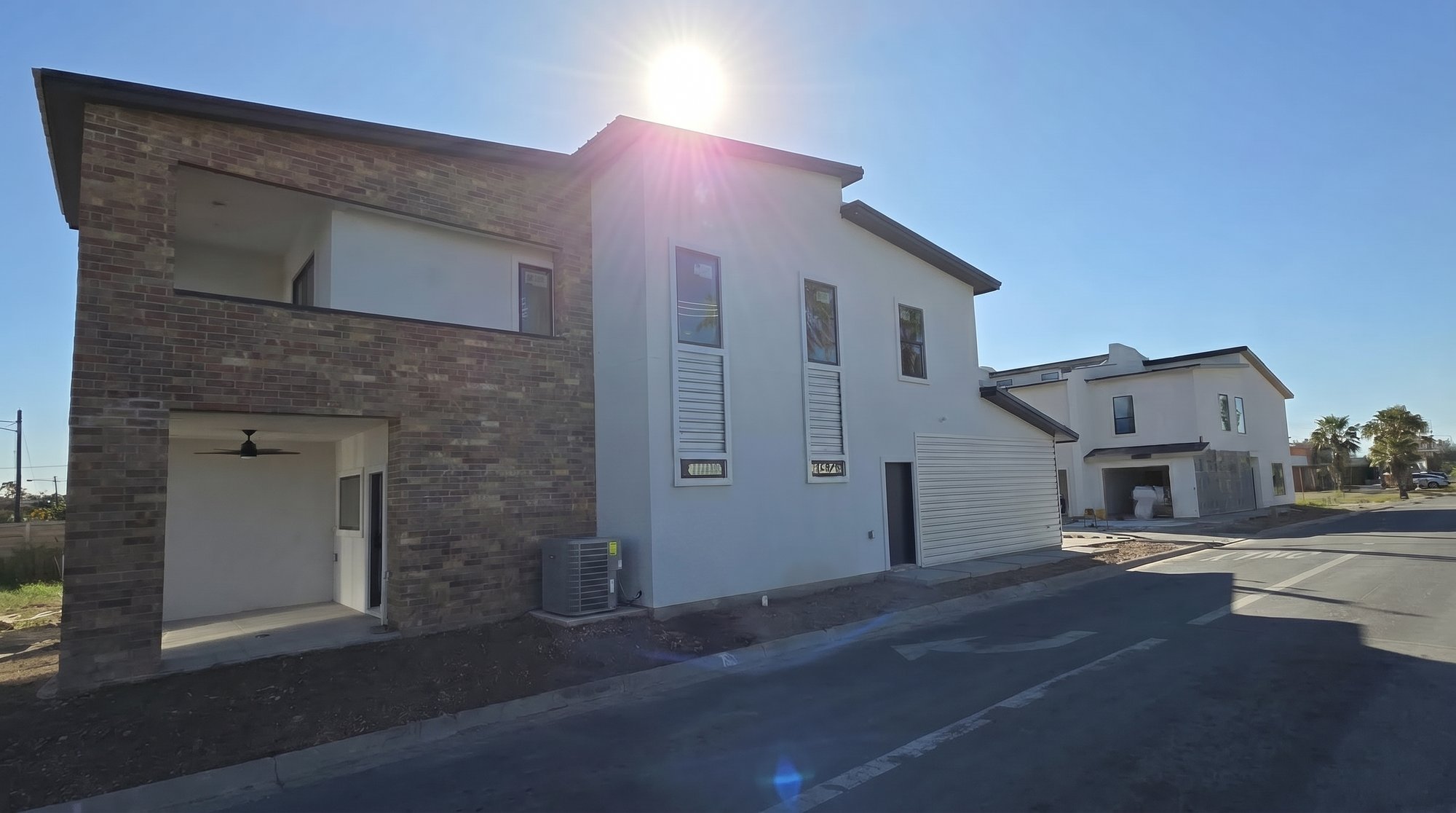 The Houston · corner profile showing Mesa Tan brick veneer, Dove Gray stucco and Tex Rib metal roof