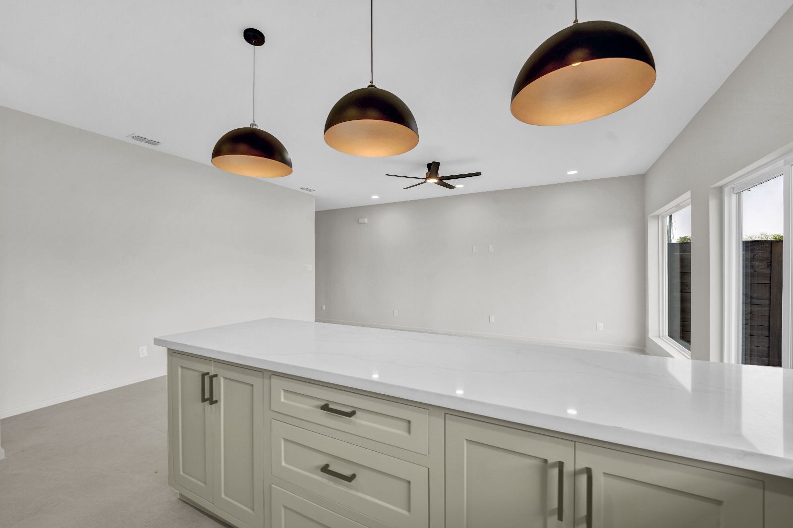 Bicentennial Townhouse · kitchen island with black pendant lights and sage cabinets