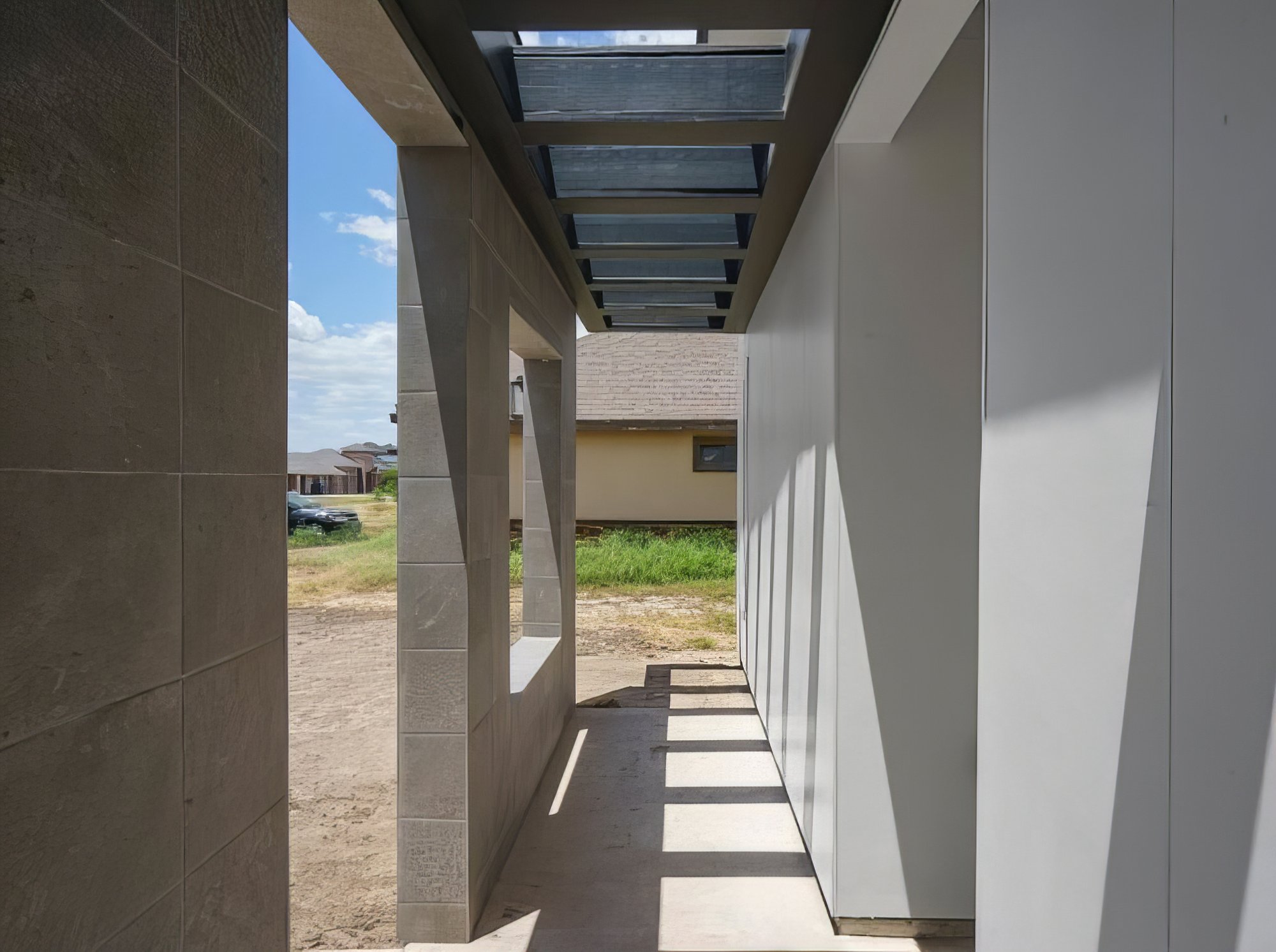 The Vincent · covered walkway with skylight slats and stone wall