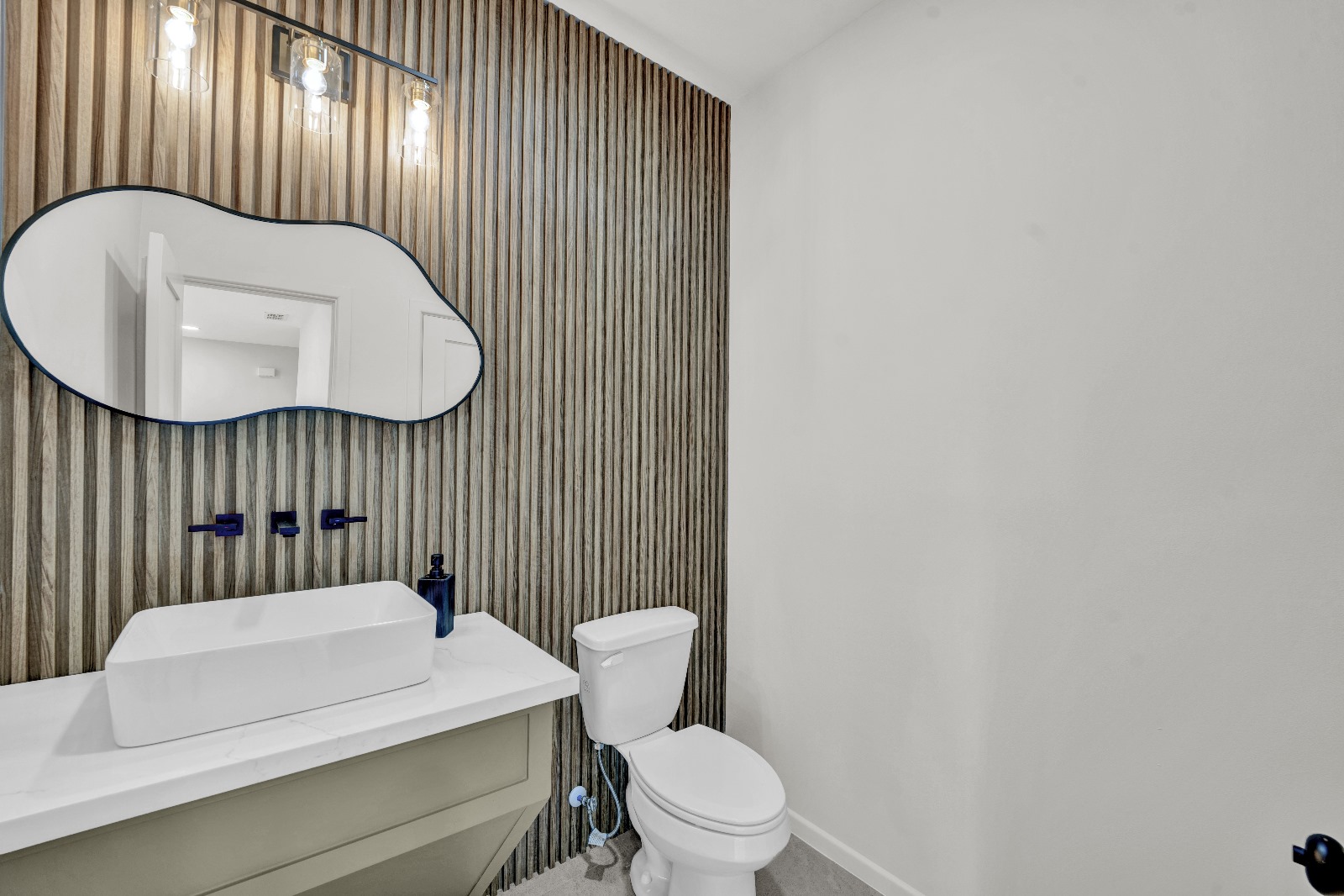 Bicentennial Townhouse · downstairs half bath with wood slat wall and organic mirror