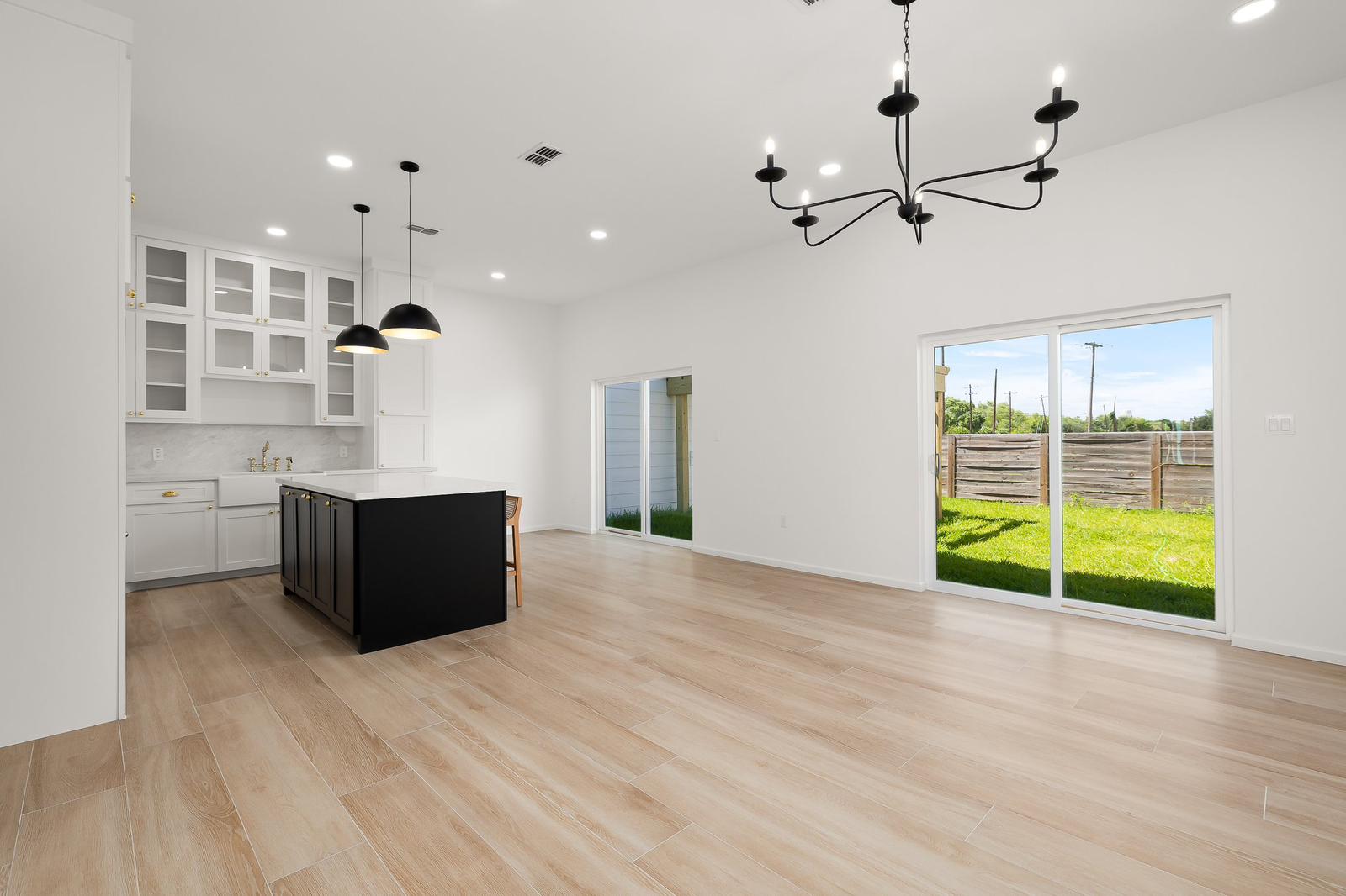 Cassandra Row · open kitchen and dining with branched chandelier and sliding doors