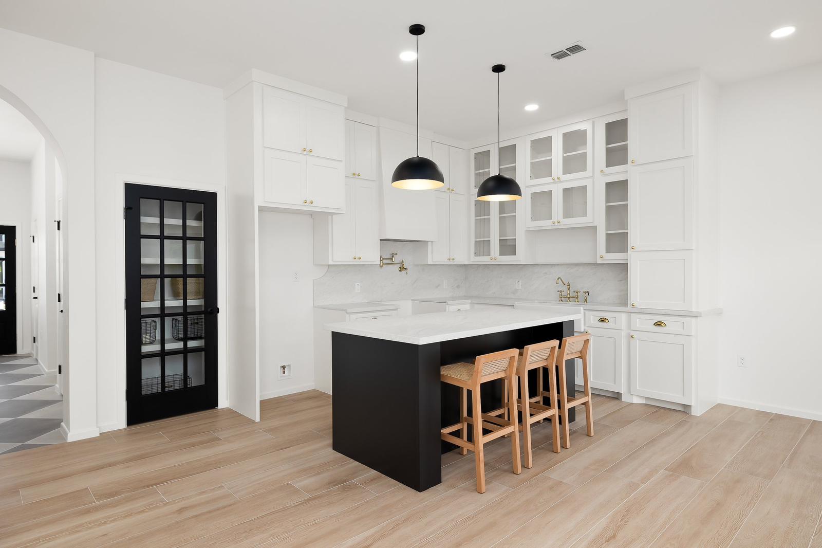 Cassandra Row · kitchen with arched opening and grey and white checker tile floor