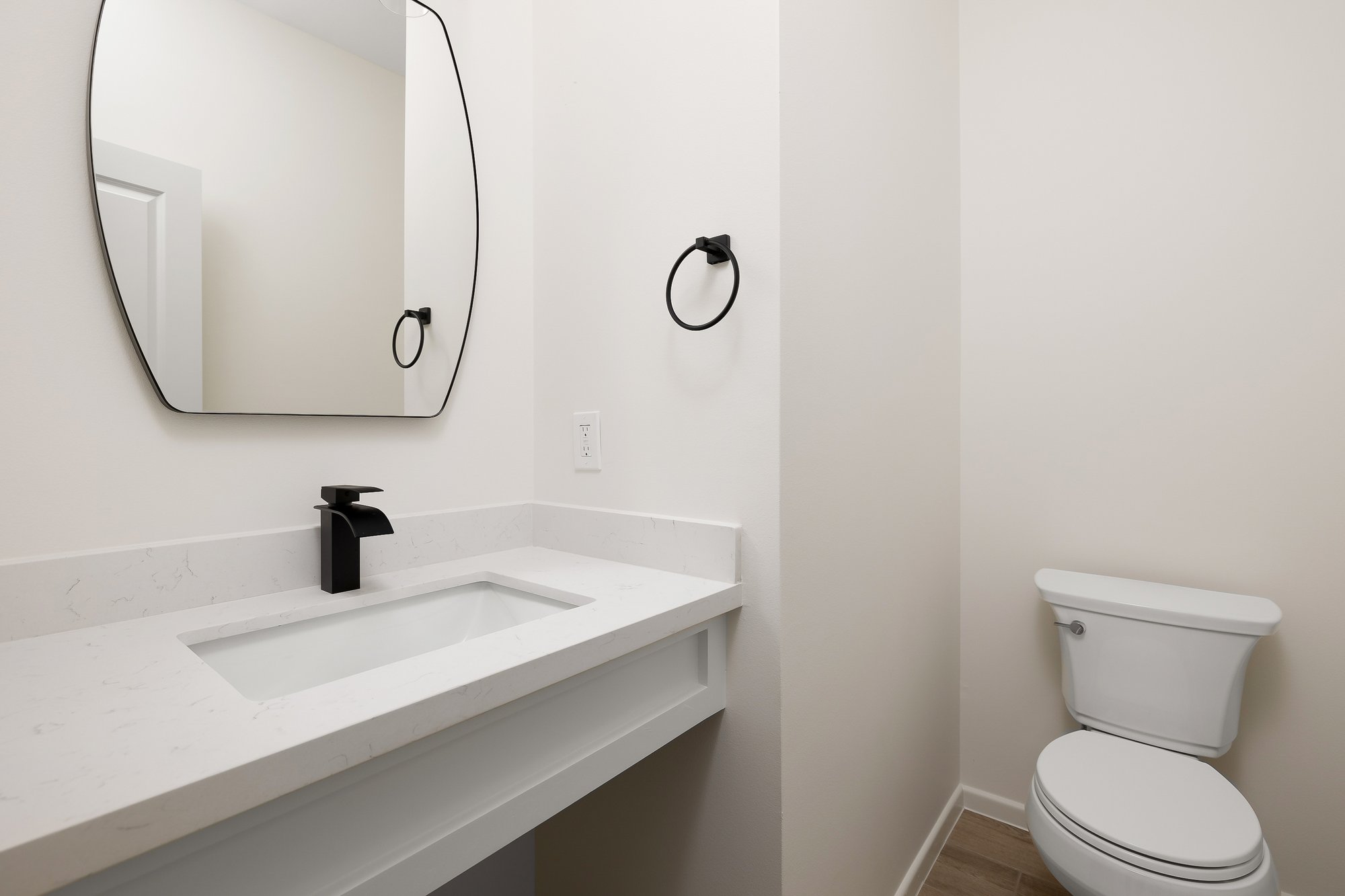 Stablewood · powder room with organic mirror and waterfall quartz vanity