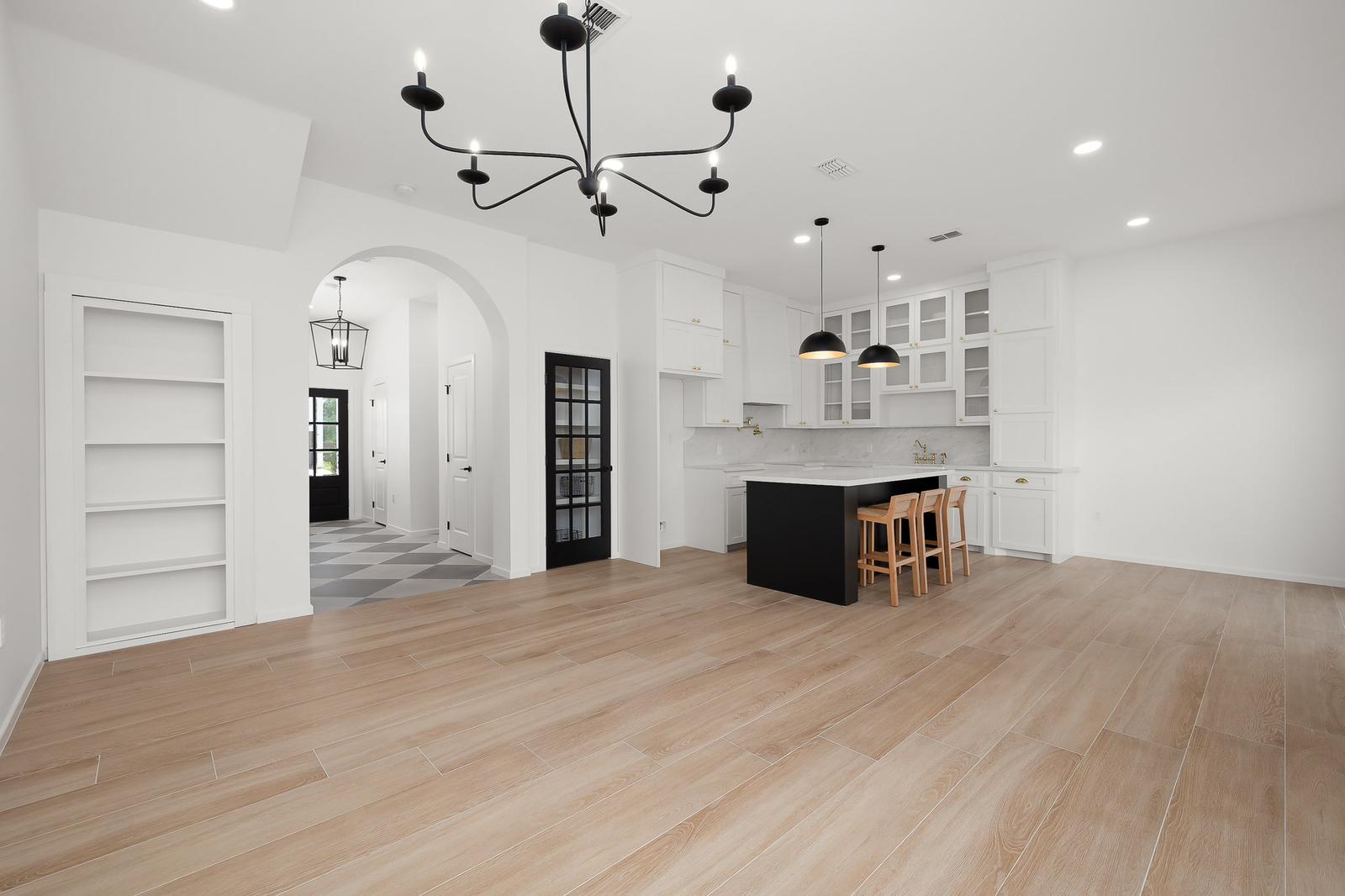 Cassandra Row · black island with cane bar stools and chandelier