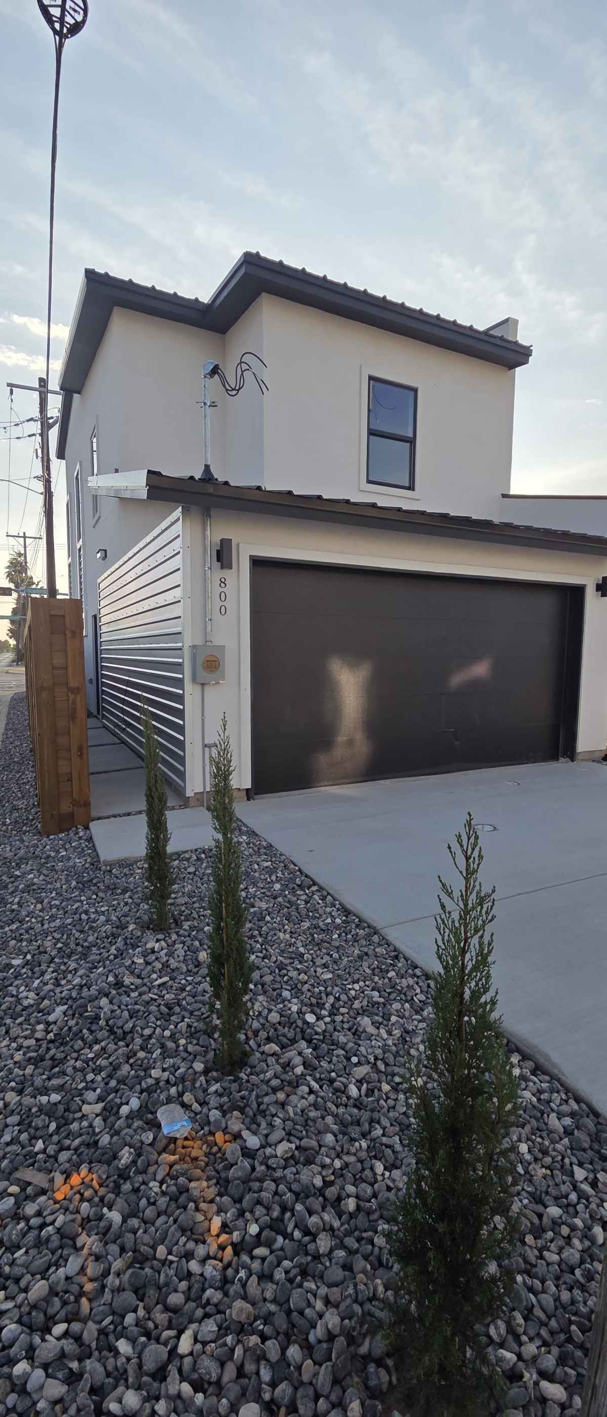 The Houston front elevation with Dove Gray stucco, black garage and metal screen detail