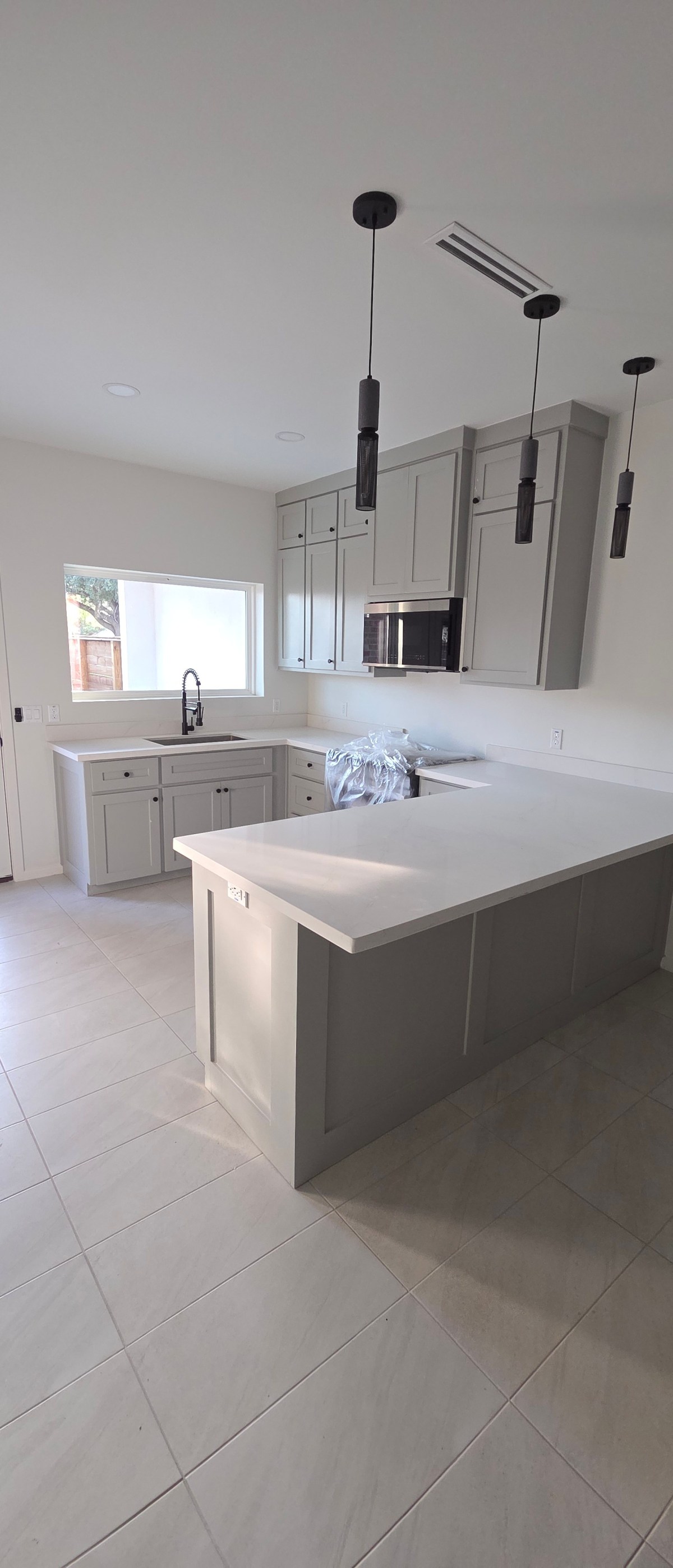 The Houston kitchen with gray shaker cabinets and slim pendant lights