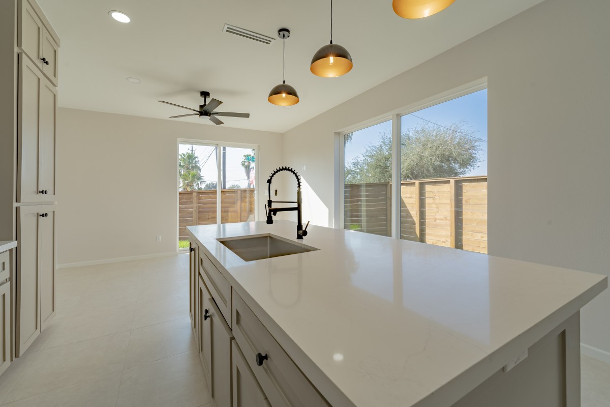 Three Sisters kitchen island top with quartz counter and brass dome pendants